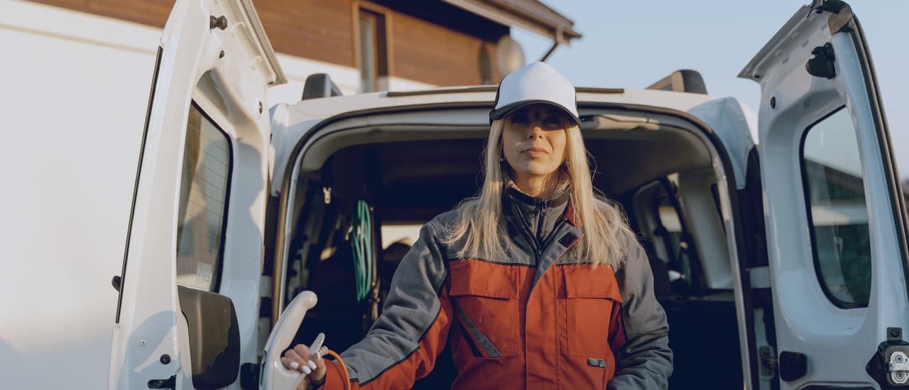 Tradesperson standing at the open back of a work van at the end of the day